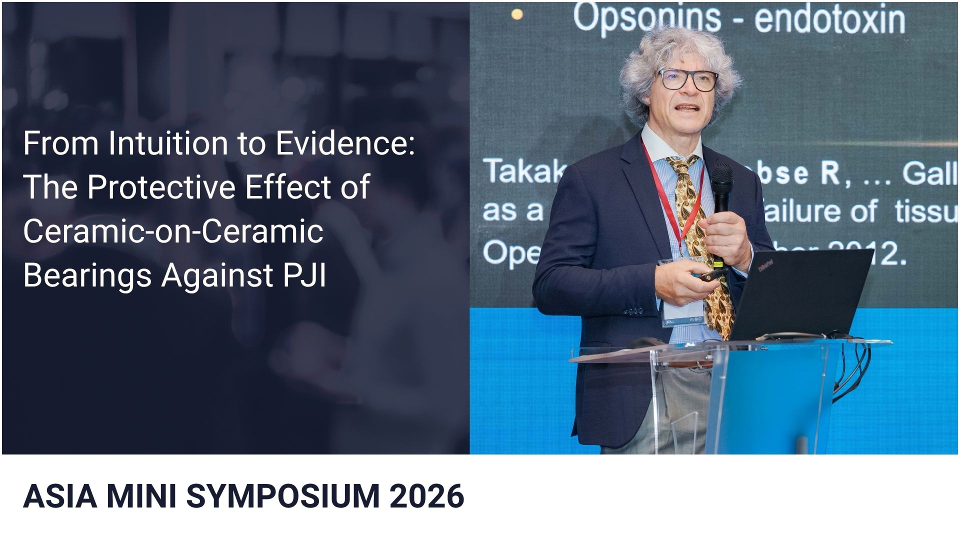 Prof. Dr. Richard Trebše  with microphone presenting at a lectern with a laptop; a slide with scientific text is projected behind him